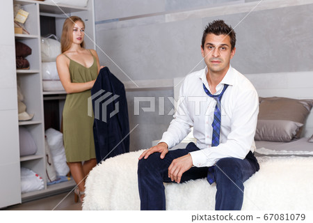 Man in bedroom and woman with his jacket Man in bedroom and woman with his jacket 67081079