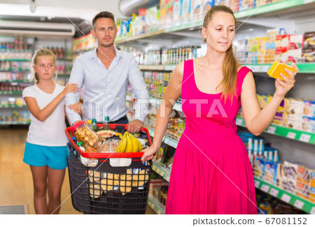 family of three choosing food in the grocery shop family of three choosing food in the grocery shop 67081152