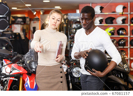 Nice shopping assistant helping male customer Nice shopping assistant helping male customer 67081157