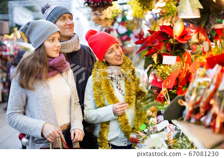 Smiling parents with teenage girl at counter with Poinsettia and floral decorations Smiling parents with teenage girl at counter with Poinsettia and floral decorations 67081230