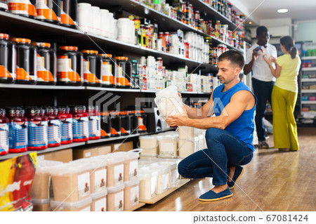 Man choosing food supplements in store 67081424