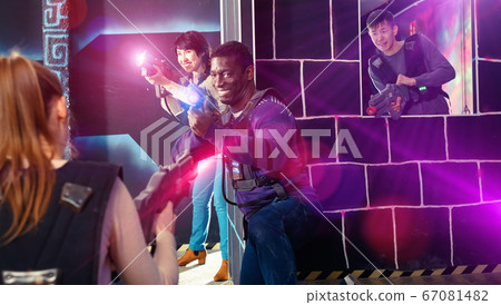 Modern people of different nationalities with laser pistols play Modern people of different nationalities with laser pistols play 67081482