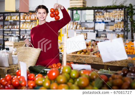 Young girl buying tomatoes at market 67081727