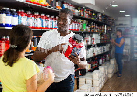 Woman choosing sports supplements in store 67081854