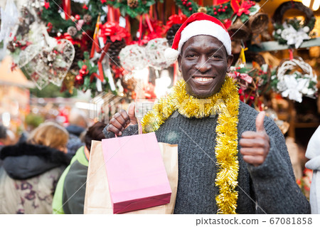 Laughing guy in Santa hat after Christmas shopping Laughing guy in Santa hat after Christmas shopping 67081858