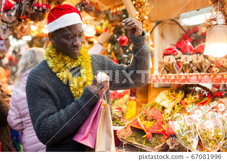 Man in Santa hat looking for New Year decorations Man in Santa hat looking for New Year decorations 67081996
