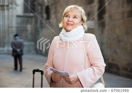 Mature woman with map and baggage Mature woman with map and baggage 67081998