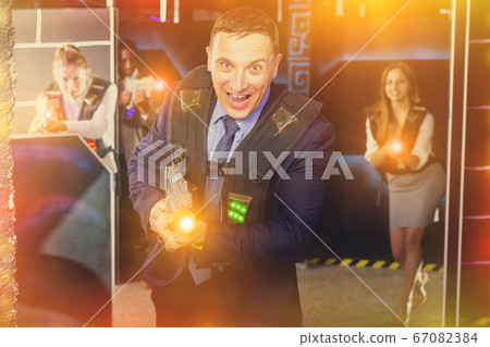 Businessman playing laser tag Businessman playing laser tag 67082384