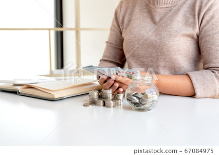 Women are counting banknotes dollars on the table with coins saving money stepping into a growing business for success and taking notes 67084975