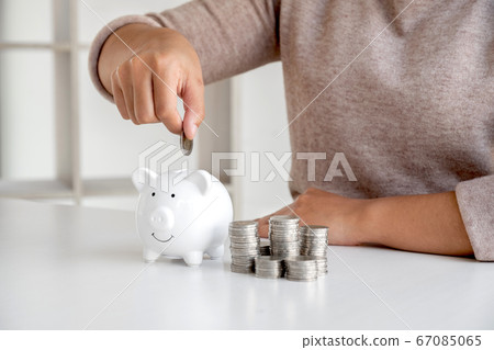 Women are putting coins in the piggy bank Saving money with coins Step into a business that is growing to be successful and save for retirement ideas 67085065