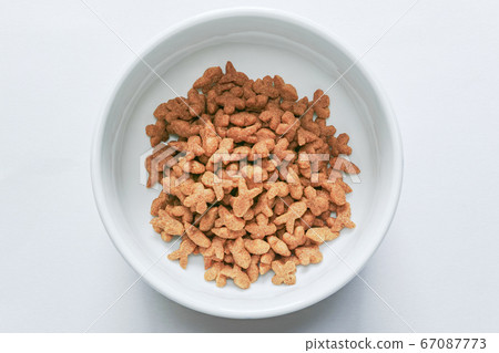 Brown cat food in white pottery in white background top view Brown cat food in white pottery in white background top view 67087773