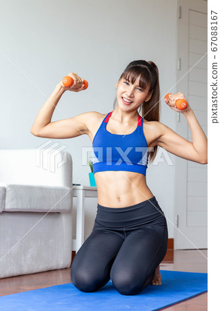 Sporty girl having weight exercise at home Sporty girl having weight exercise at home 67088167