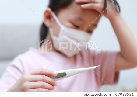 An infant who is in poor physical condition wearing a mask to measure body temperature An infant who is in poor physical condition wearing a mask to measure body temperature 67088551