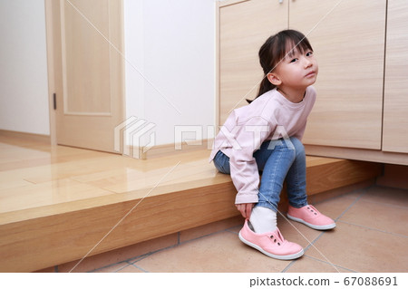 4-year-old girl wearing shoes at the entrance 67088691