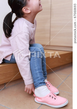 4-year-old girl wearing shoes at the entrance 67088693