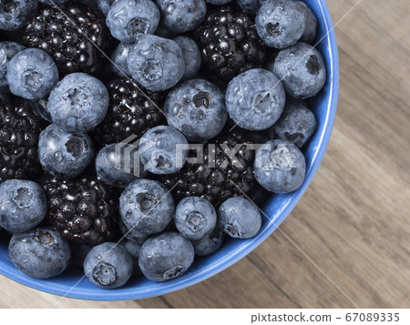 Forest berries (blueberry,bramble) in a bowl 67089335