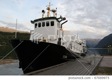 Norway Hardanger Fjord, a small sightseeing boat moored at a wharf to the southeast of a hotel in Ulvik Norway Hardanger Fjord, a small sightseeing boat moored at a wharf to the southeast of a hotel in Ulvik 67089973
