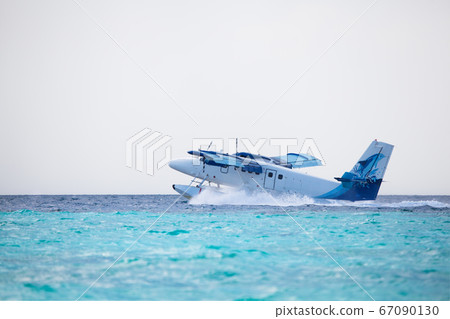 Seaplane is landing on water near an island Seaplane is landing on water near an island 67090130