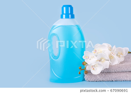 Bottle of detergent with clean towels and flowers 67090691
