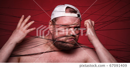 Fat man tangled in black threads on red background 67091409