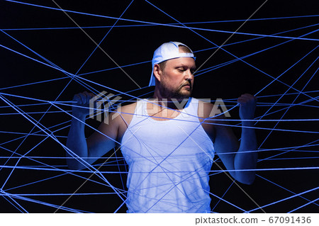 Photo of stout man with white threads in neon light Photo of stout man with white threads in neon light 67091436