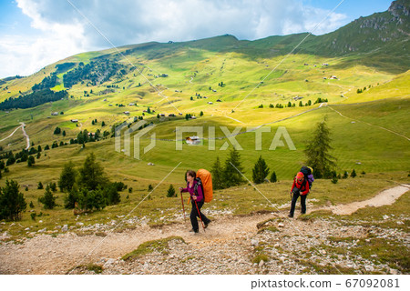 Sporty Young women on mountain trail Dolomites Mountains, Italy Sporty Young women on mountain trail Dolomites Mountains, Italy 67092081