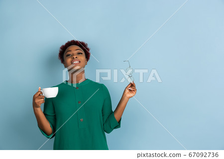 African-american beautiful young woman's portrait on blue studio background, emotional and expressive. Copyspace for ad. 67092736