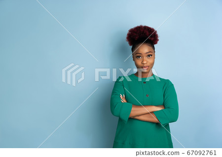 African-american beautiful young woman's portrait on blue studio background, emotional and expressive. Copyspace for ad. 67092761