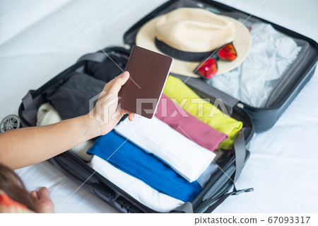 Young adult female packing luggage for summer Young adult female packing luggage for summer 67093317