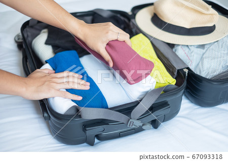 Young adult female packing luggage for summer Young adult female packing luggage for summer 67093318