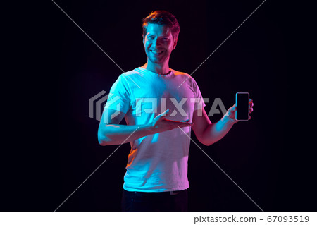 Caucasian beautiful young man's portrait on black studio background, emotional and expressive. Copyspace for ad. Caucasian beautiful young man's portrait on black studio background, emotional and expressive. Copyspace for ad. 67093519