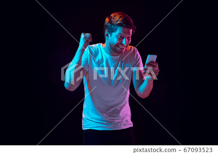 Caucasian beautiful young man's portrait on black studio background, emotional and expressive. Copyspace for ad. 67093523