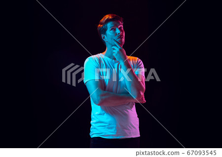 Caucasian beautiful young man's portrait on black studio background, emotional and expressive. Copyspace for ad. 67093545