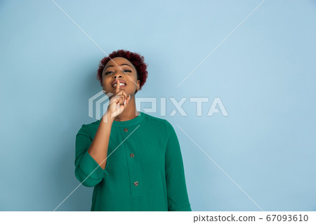 African-american beautiful young woman's portrait on blue studio background, emotional and expressive. Copyspace for ad. African-american beautiful young woman's portrait on blue studio background, emotional and expressive. Copyspace for ad. 67093610