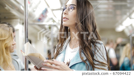 The girl goes to the subway and reads a book The girl goes to the subway and reads a book 67094422