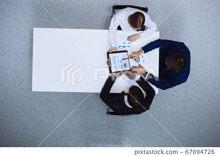 Group of business people analyzing financial documents, view from above. Business team at meeting Group of business people analyzing financial documents, view from above. Business team at meeting 67094726