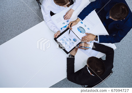 Group of business people analyzing financial documents, view from above. Business team at meeting Group of business people analyzing financial documents, view from above. Business team at meeting 67094727