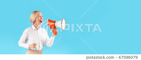 Woman in office wear shouting into megaphone on blue background, space for text 67096079