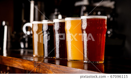 Many varieties of craft beer. Misted glass goblets with ale, lager, and unfiltered drink on bar Many varieties of craft beer. Misted glass goblets with ale, lager, and unfiltered drink on bar 67096115