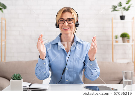 Work from home and video call. Woman with headset, gesticulation to camera Work from home and video call. Woman with headset, gesticulation to camera 67096219