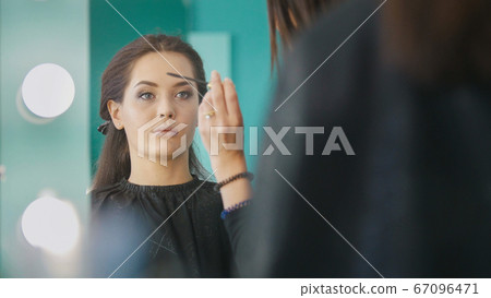 Makeup artist, hairdresser working with client in the beauty salon, shaping and coloring eyebrows Makeup artist, hairdresser working with client in the beauty salon, shaping and coloring eyebrows 67096471