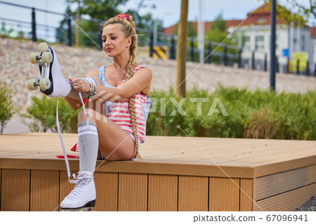 girl in an American T-shirt with roller skates girl in an American T-shirt with roller skates 67096941