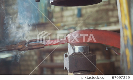 The blacksmith manually forging in the smithy The blacksmith manually forging in the smithy 67097239