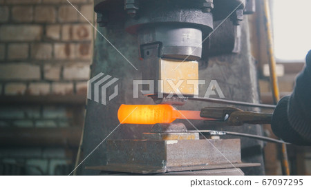 Blacksmith with hammer in forge creating steel knife Blacksmith with hammer in forge creating steel knife 67097295