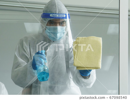 Staff is spraying disinfectant and wiping clean Staff is spraying disinfectant and wiping clean 67098540
