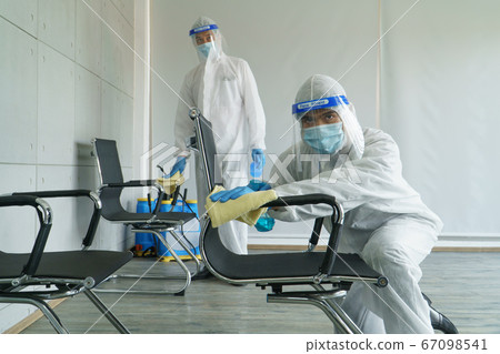 Staff is spraying disinfectant and wiping clean Staff is spraying disinfectant and wiping clean 67098541