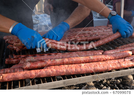 Sausage lined up on a large outdoor grill Sausage lined up on a large outdoor grill 67099078