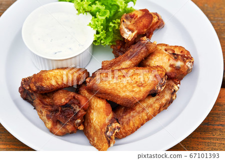 A plate of chicken wings on a table A plate of chicken wings on a table 67101393