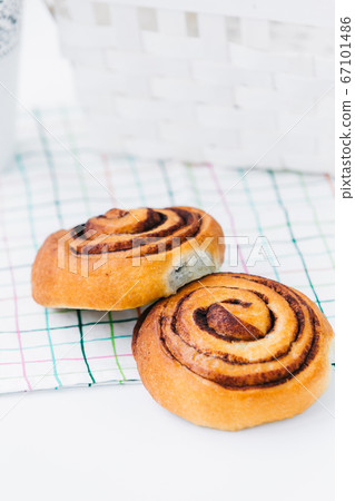 A cinnamon bun on a napkin on white A cinnamon bun on a napkin on white 67101486