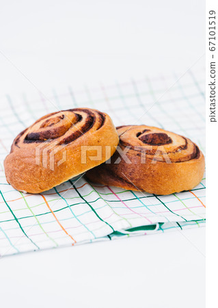 A cinnamon bun on a napkin on white A cinnamon bun on a napkin on white 67101519